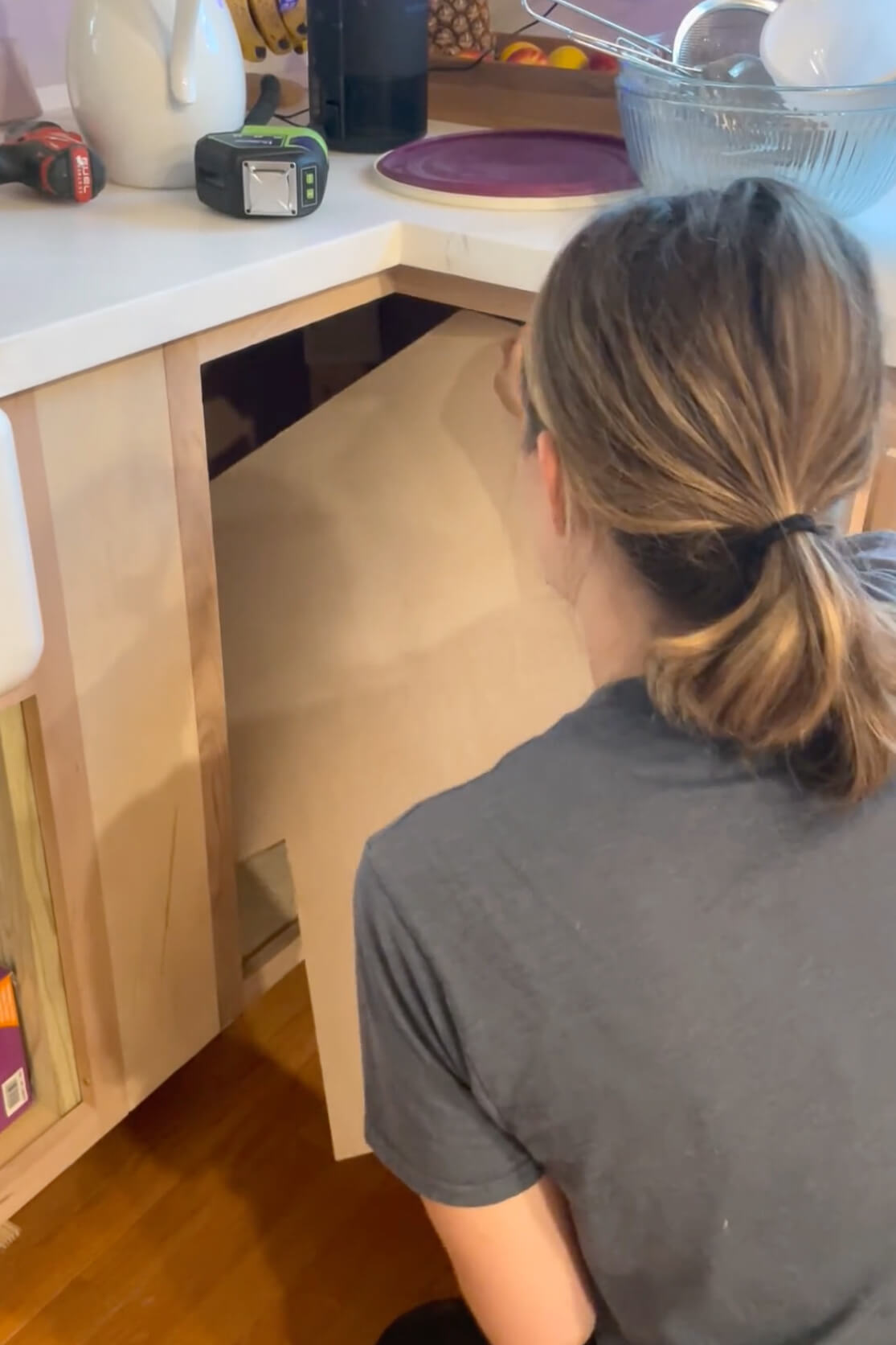 Fitting a shelf into a DIY kitchen cabinet.